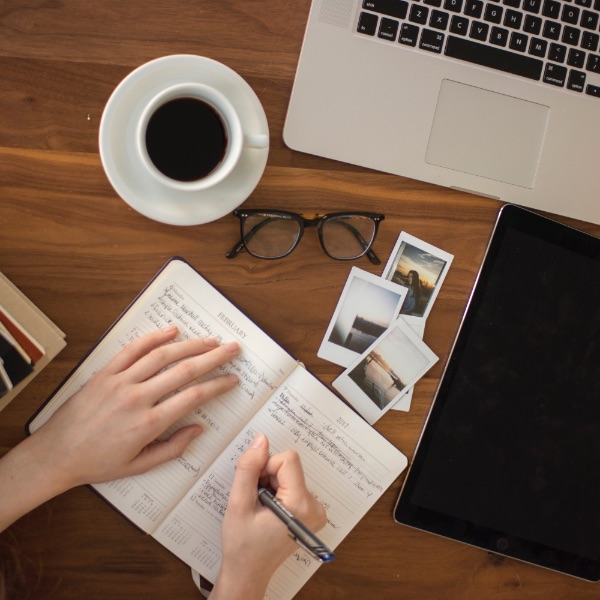 Schreibtisch mit Computer, handschriftliche Notizen.